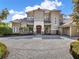 Luxurious home showcases a paved circular driveway, manicured shrubs, and a grand entrance with double doors at 11306 Bridge House Rd, Windermere, FL 34786