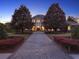 Elegant home with lush landscaping and a paved driveway leading to the grand entrance at twilight at 11306 Bridge House Rd, Windermere, FL 34786