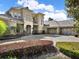 A beautiful home features a well-manicured lawn, circular driveway, and a three-car garage at 11306 Bridge House Rd, Windermere, FL 34786