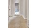 Hallway with marble tile flooring and white trim, leading to a bright, windowed door at 11306 Bridge House Rd, Windermere, FL 34786