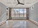 Bright living room featuring a tray ceiling, tiled floors, and large picture window at 11306 Bridge House Rd, Windermere, FL 34786