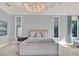 Comfortable bedroom with pale blue colors, soft carpet and a lovely hanging light fixture at 11306 Bridge House Rd, Windermere, FL 34786