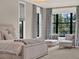 Well-lit and comfortable bedroom with a neutral palette, large windows and sitting chairs at 11306 Bridge House Rd, Windermere, FL 34786