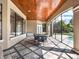 Beautiful outdoor patio with decorative wood ceiling, tile flooring, and view of the pool at 11306 Bridge House Rd, Windermere, FL 34786