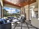 Elegant screened-in patio with a stone fireplace, outdoor kitchen, and comfortable seating at 11306 Bridge House Rd, Windermere, FL 34786