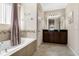 Well-appointed bathroom with a soaking tub, double vanity, and elegant finishes at 12189 Beach Fern Rd, Orlando, FL 32824