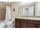 Bathroom featuring a double sink vanity, tiled flooring, a toilet, and a shower with a colorful curtain at 12189 Beach Fern Rd, Orlando, FL 32824