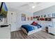 Bedroom showcasing a light grey paint, wood floor, ceiling fan, and a Superhero themed wall decor at 12189 Beach Fern Rd, Orlando, FL 32824