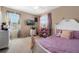 Bright bedroom features dual windows, ceiling fan, carpeted floor, and a TV with a stylish white bed frame at 12189 Beach Fern Rd, Orlando, FL 32824
