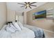 Spacious bedroom featuring a ceiling fan and mounted TV for relaxing entertainment at 12189 Beach Fern Rd, Orlando, FL 32824