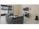 Modern living room with tile flooring, gray sectional couch, and sliding door to lanai at 12189 Beach Fern Rd, Orlando, FL 32824