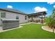 Backyard oasis with artificial grass, hot tub, outdoor kitchen, and pergola, designed for leisure and entertainment at 13227 Spring Grove Way, Winter Garden, FL 34787