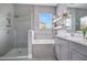 Modern bathroom featuring a glass enclosed shower and a soaking tub with a view at 13227 Spring Grove Way, Winter Garden, FL 34787