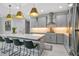 Bright, modern kitchen with stainless steel appliances, gray cabinets, and an island with seating at 13227 Spring Grove Way, Winter Garden, FL 34787