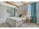Cozy main bedroom featuring a plush bed, wood ceiling beams, and bright windows with patterned drapes at 13227 Spring Grove Way, Winter Garden, FL 34787