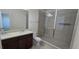 Bathroom featuring double sinks with granite countertops, dark wood cabinets and a walk-in shower at 15471 Honeybell Dr, Winter Garden, FL 34787