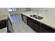 Kitchen island with stainless steel sink, faucet, dishwasher, and quartz countertop at 15471 Honeybell Dr, Winter Garden, FL 34787