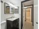 Bright bathroom featuring a vanity, mirror with lighting, and an open doorway to the updated shower at 170 Palmetto Woods Ct # 3A, Deltona, FL 32725