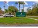 Exterior shot of the 'Edgewater Condominiums' sign surrounded by green grass and palm trees against a cloudy sky at 170 Palmetto Woods Ct # 3A, Deltona, FL 32725