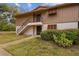 Inviting two-story exterior featuring well-maintained siding, trimmed bushes, and a staircase leading to the upper level entrance at 170 Palmetto Woods Ct # 3A, Deltona, FL 32725