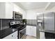 Modern kitchen with stainless steel appliances including a refrigerator, microwave, and range, complemented by granite countertops at 170 Palmetto Woods Ct # 3A, Deltona, FL 32725
