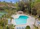 Inviting community pool featuring lounge chairs and tables amid mature palm trees and well-maintained grounds at 170 Palmetto Woods Ct # 3A, Deltona, FL 32725