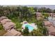 Aerial view of a community pool with lounge chairs surrounded by mature trees and condominium buildings at 170 Palmetto Woods Ct # 3A, Deltona, FL 32725