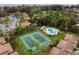 Aerial view of the tennis courts and swimming pool with condominium buildings nestled among the trees at 170 Palmetto Woods Ct # 3A, Deltona, FL 32725