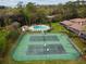 Aerial view of community tennis courts, swimming pool, and lounge area surrounded by trees and nature at 170 Palmetto Woods Ct # 3A, Deltona, FL 32725