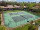 Aerial view showcasing tennis courts with green playing surface, surrounded by trees and condominiums at 170 Palmetto Woods Ct # 3A, Deltona, FL 32725