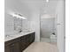 Elegant bathroom featuring double sinks, modern fixtures, and a spacious glass-enclosed shower with a bench at 200 Snowy Orchid Way, Lake Alfred, FL 33850