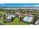 Aerial view of a community clubhouse showcasing pool, tennis courts, and lush greenery at 200 Snowy Orchid Way, Lake Alfred, FL 33850
