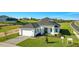 Beautiful home featuring a two-car garage, modern front door, and freshly planted landscaping at 200 Snowy Orchid Way, Lake Alfred, FL 33850