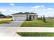 Beautiful home exterior featuring a two-car garage, manicured lawn and paved driveway at 200 Snowy Orchid Way, Lake Alfred, FL 33850
