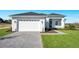 Charming home exterior with a paved driveway, two-car garage, and well-manicured lawn at 200 Snowy Orchid Way, Lake Alfred, FL 33850