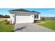 Beautiful home exterior featuring a two-car garage, manicured lawn and paved driveway at 200 Snowy Orchid Way, Lake Alfred, FL 33850