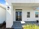Inviting front entrance features a modern black door and stylish gray pavers at 200 Snowy Orchid Way, Lake Alfred, FL 33850