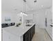 Bright kitchen with white cabinets, stainless steel appliances, and a large center island with a sink at 200 Snowy Orchid Way, Lake Alfred, FL 33850