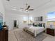 Bright and airy main bedroom with a tray ceiling, large windows, and neutral decor at 200 Snowy Orchid Way, Lake Alfred, FL 33850