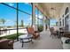 Inviting outdoor lounge area with comfortable seating, overlooking a beautiful pool, landscape, and clear blue sky at 200 Snowy Orchid Way, Lake Alfred, FL 33850