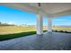 Inviting outdoor patio with stone pavers offering serene views of the lush backyard at 200 Snowy Orchid Way, Lake Alfred, FL 33850