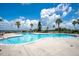 Inviting outdoor swimming pool with clear blue water, surrounded by palm trees, and a view of the lake under a blue sky at 200 Snowy Orchid Way, Lake Alfred, FL 33850
