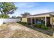 View of the backyard showcasing the yellow exterior, white fence, and green shrubs at 2101 Lake Francis Dr, Apopka, FL 32712