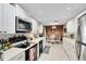 Well-lit kitchen with white cabinetry, black appliances, and a cozy dining area at 2101 Lake Francis Dr, Apopka, FL 32712