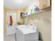 Functional laundry room with updated washer and dryer and built-in storage shelf at 2101 Lake Francis Dr, Apopka, FL 32712