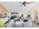 Cozy living room features a modern sectional, ceiling fan, and sliding glass doors to the lanai at 2101 Lake Francis Dr, Apopka, FL 32712