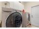 Practical laundry room featuring a front-load washer and dryer set with white cabinets at 2162 Camel Lake Ct, Oviedo, FL 32765