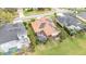 An aerial view of a single-Gathering home with a terracotta roof, solar panels, and a screened-in pool at 2326 Wintermere Pointe Dr, Winter Garden, FL 34787