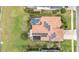 An aerial shot reveals a terra cotta roof with solar panels, a screened-in pool, and a well-manicured lawn at 2326 Wintermere Pointe Dr, Winter Garden, FL 34787