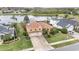 Beautiful aerial view of a lakeside property with a terracotta roof, green lawn, and mature landscaping at 2326 Wintermere Pointe Dr, Winter Garden, FL 34787
